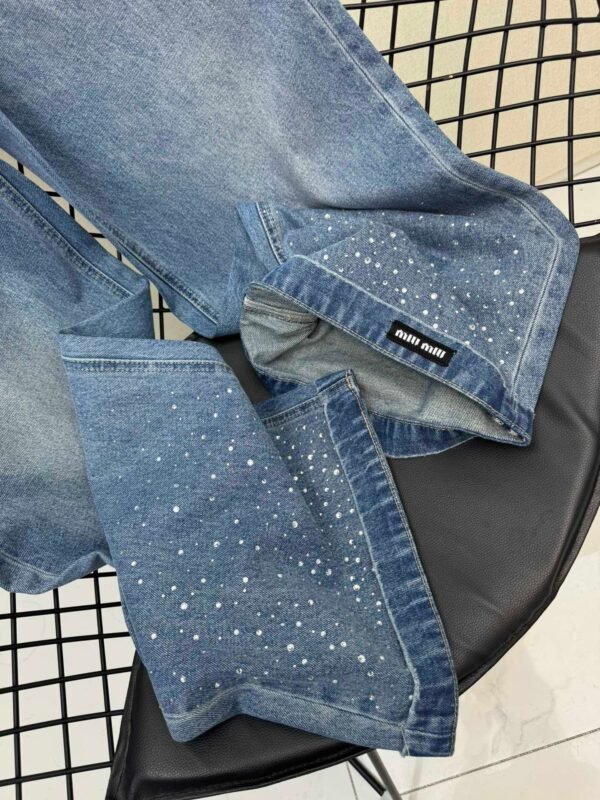 Miu Miu style jeans with rhinestone embellishments on the cuffs, made with high-quality fabric and a special washing process.